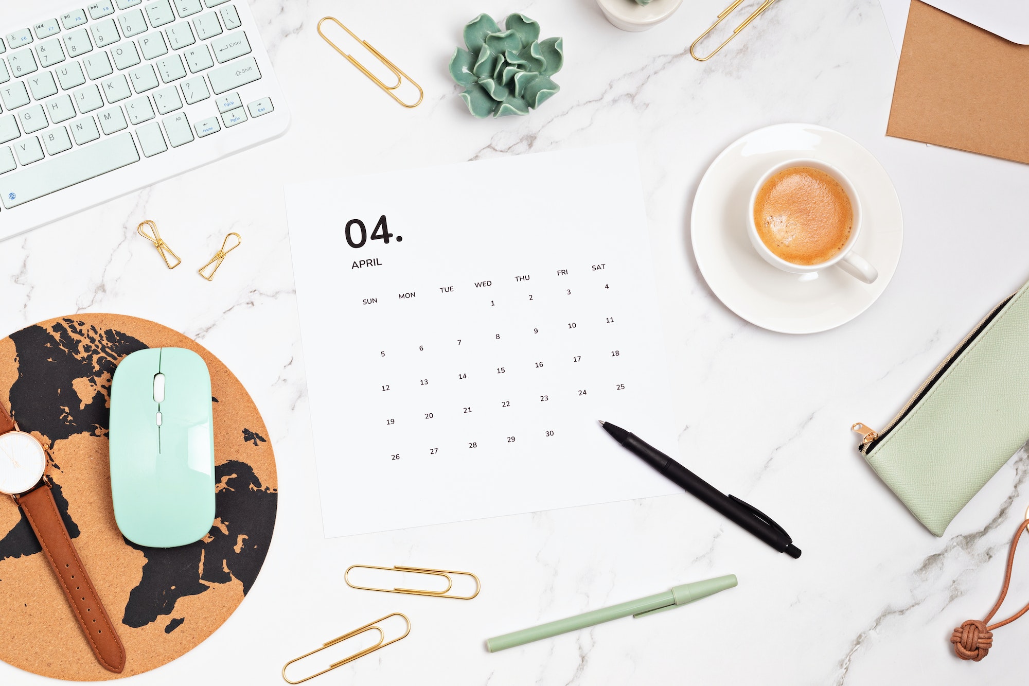 Desktop with calendar for april and office supplies. home office, social media blog, schedule